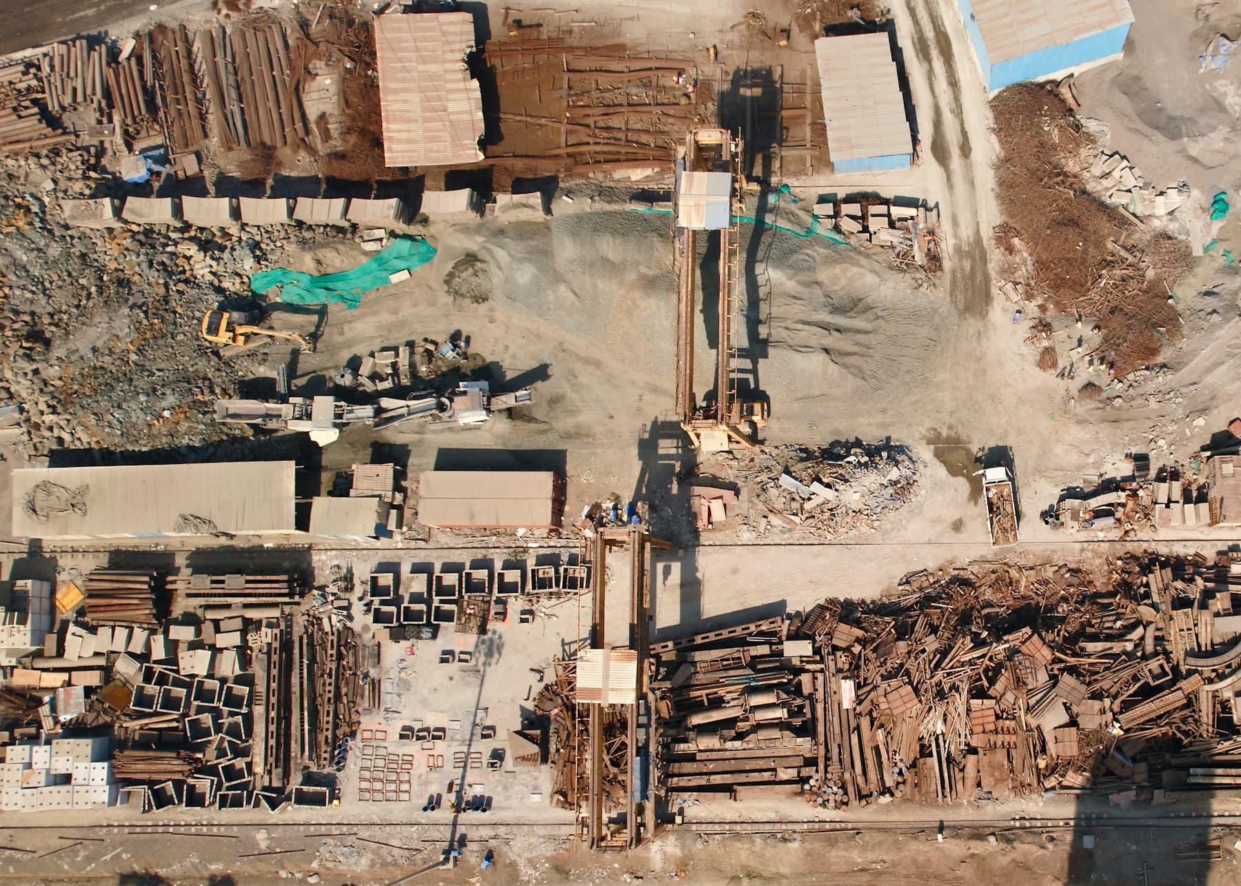 An informal scrap yard seen from above, with stacked material and bare ground